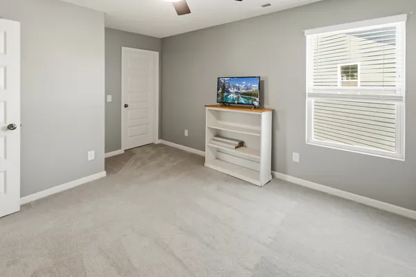 an empty room with windows and fan