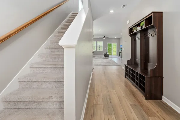 a view of a hallway with wooden floor and staircase
