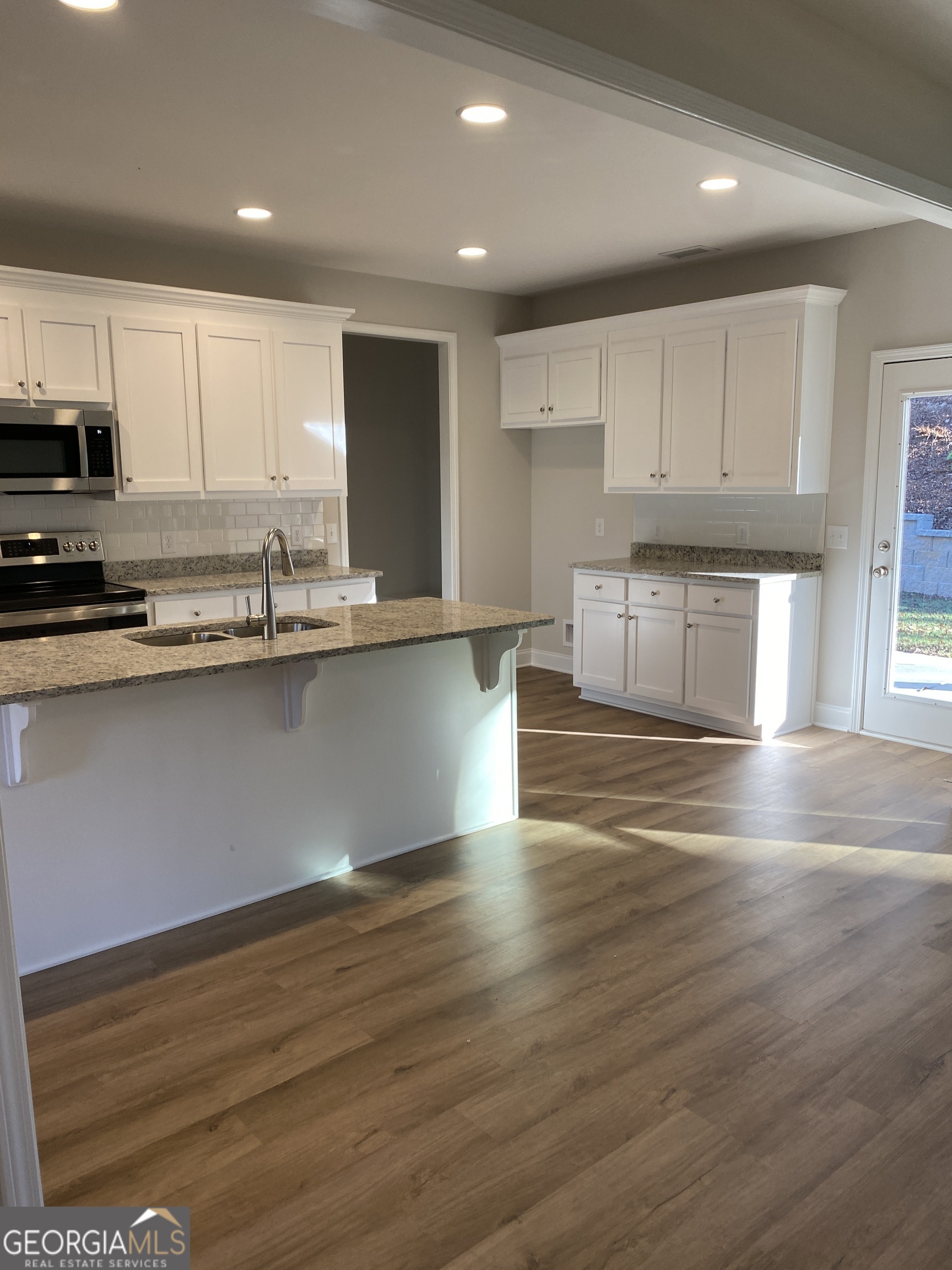 162 Delightful Way, Unit 28 Winder, GA 30680 - Photo 3 of 11 a kitchen with stainless steel appliances granite countertop a sink wooden cabinets and a granite counter tops