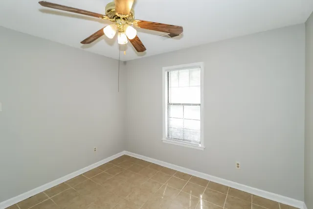 an empty room with a window and a fan