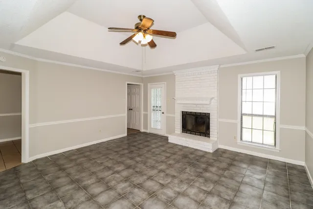 an empty room with windows and fireplace