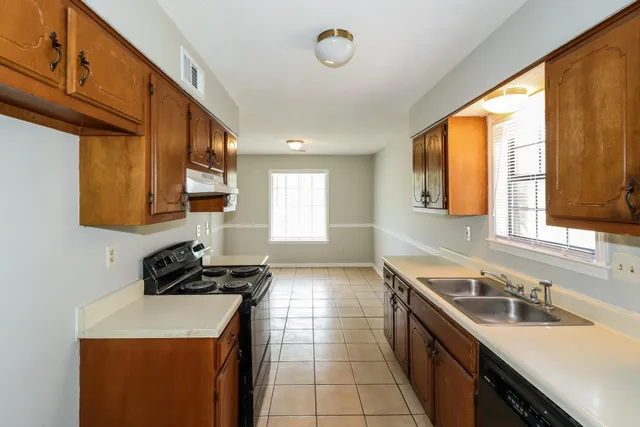 a kitchen with a sink a stove and cabinets