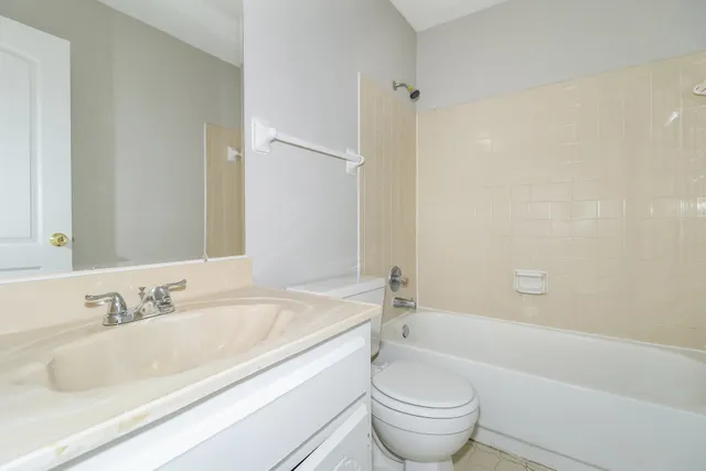 a bathroom with a granite countertop sink a toilet and a bathtub