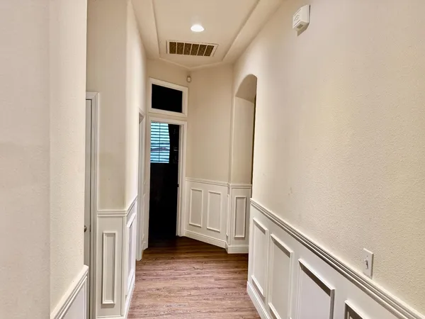 a view of a hallway with wooden floor and staircase