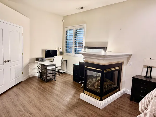 a living room with furniture a fireplace and wooden floor