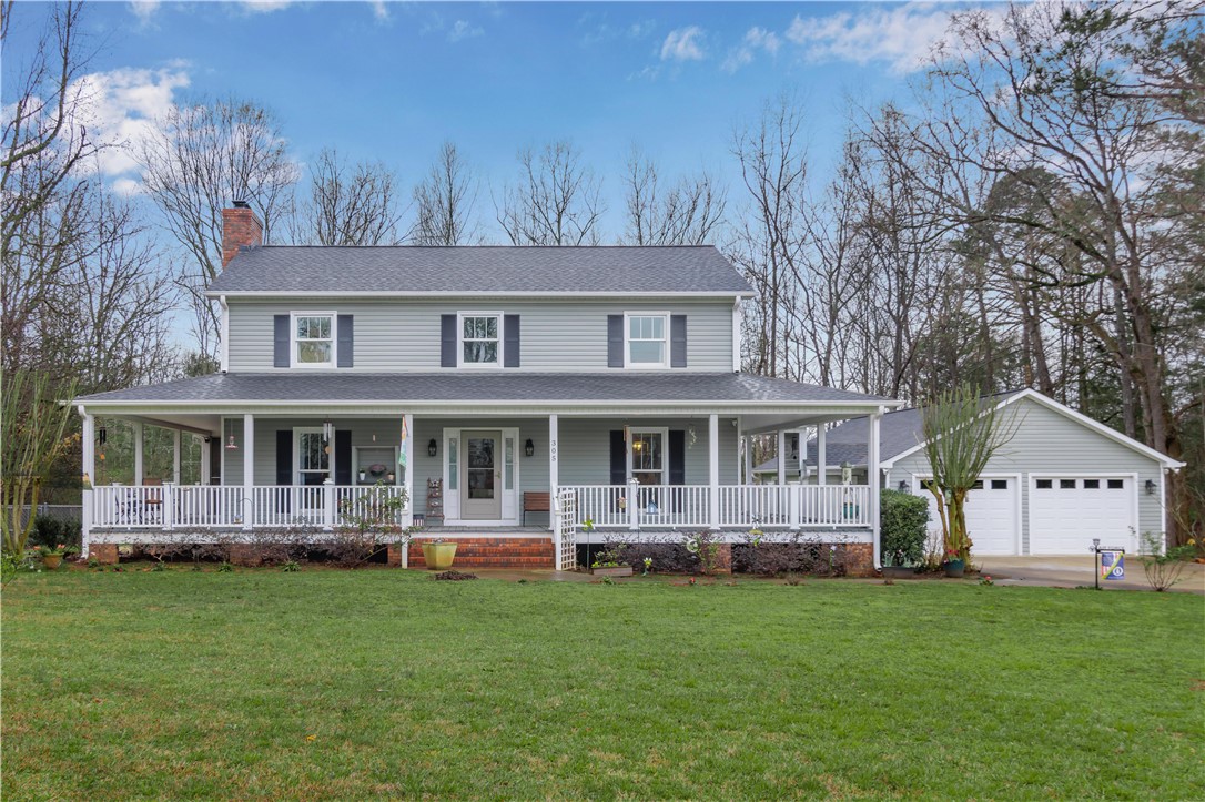 This classic two-story home features a welcoming wrap-around porch and a detached garage.