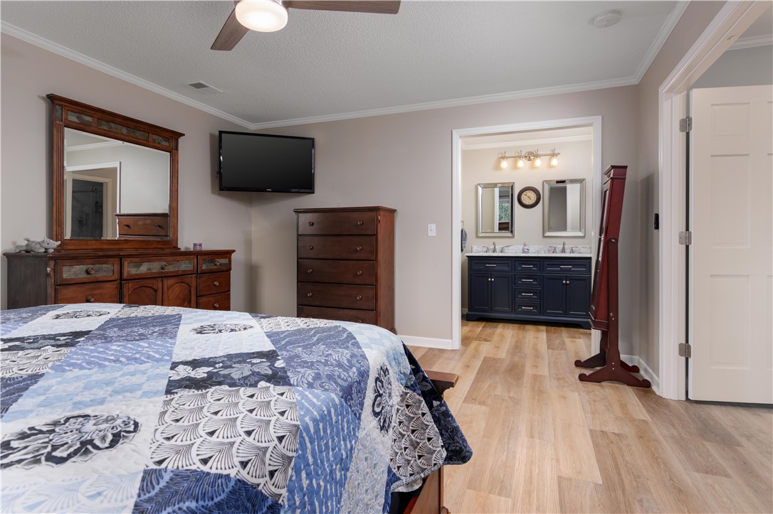 305 Farmdale Road Hodges, SC 29653 - Photo 24 of 48 This serene bedroom offers elegant crown molding, leading to a well-appointed private bath.