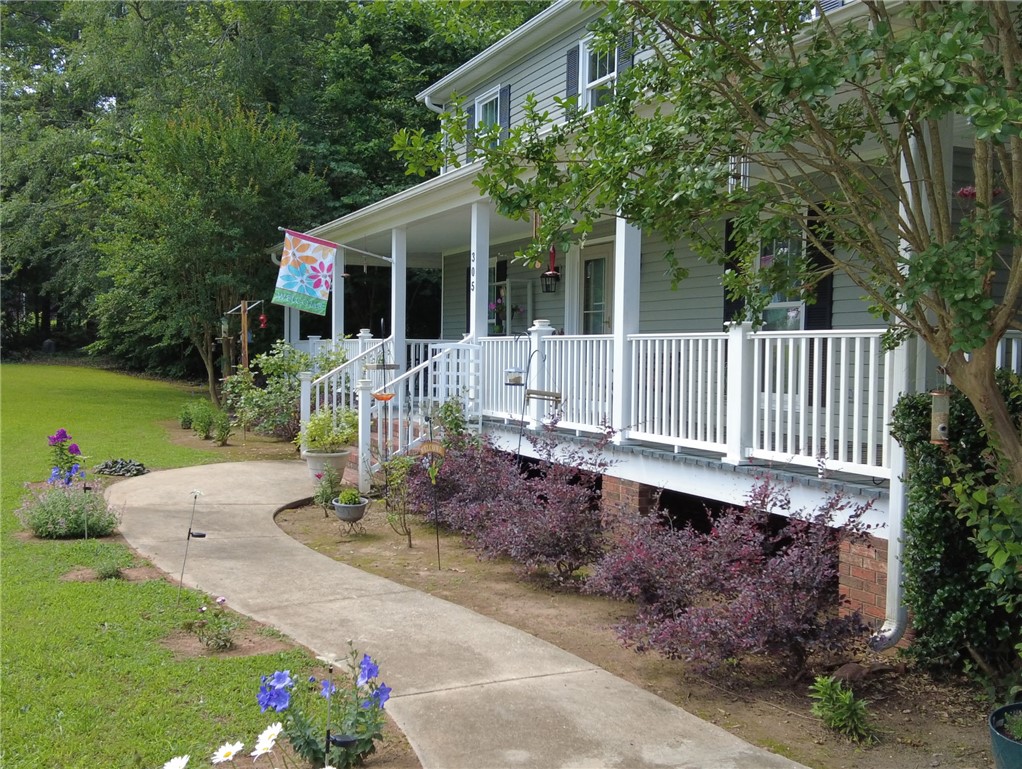 305 Farmdale Road Hodges, SC 29653 - Photo 4 of 48 Charming home featuring a welcoming front porch, mature trees, and a well-maintained lawn.