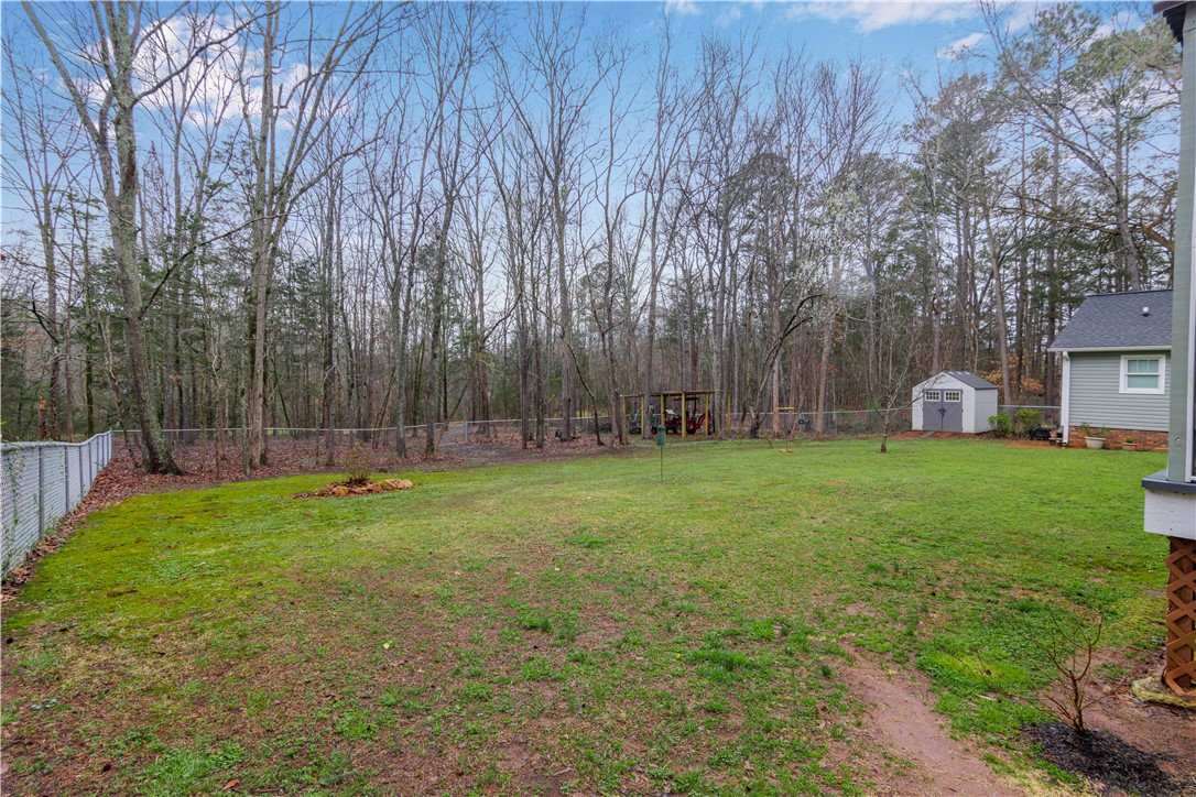 305 Farmdale Road Hodges, SC 29653 - Photo 42 of 48 Expansive green yard with mature trees, offering a private and serene outdoor living space.