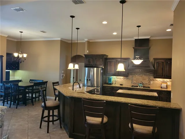 a kitchen with a sink a counter space appliances and cabinets