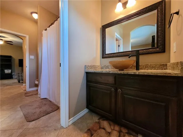 a bathroom with a granite countertop sink a mirror and a vanity