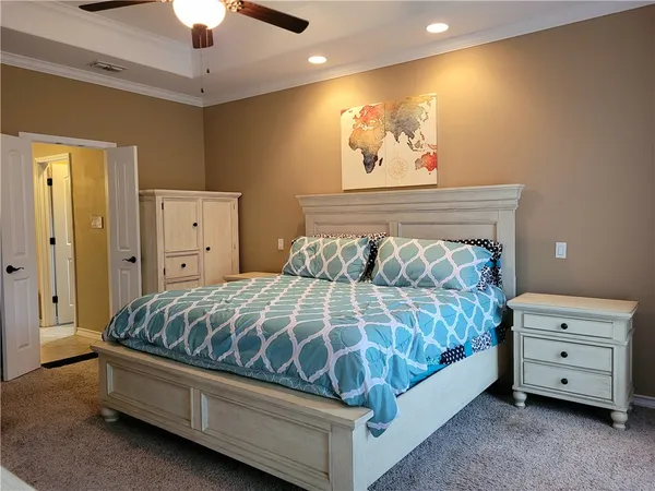 a bed room with a bed and a painting on the wall