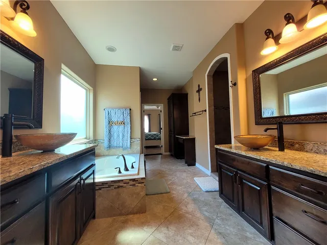 a spacious bathroom with a granite countertop sink and a mirror