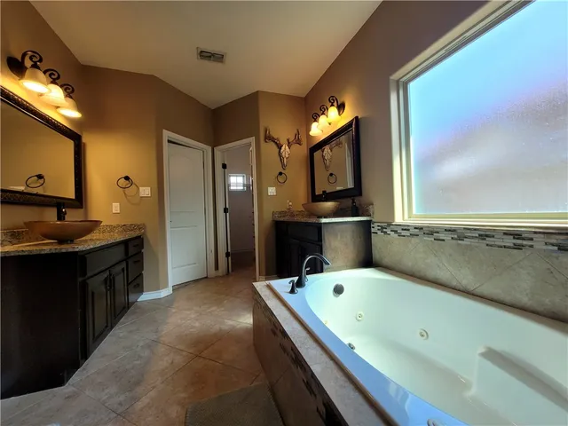 a bathroom with a bathtub and a double vanity sink