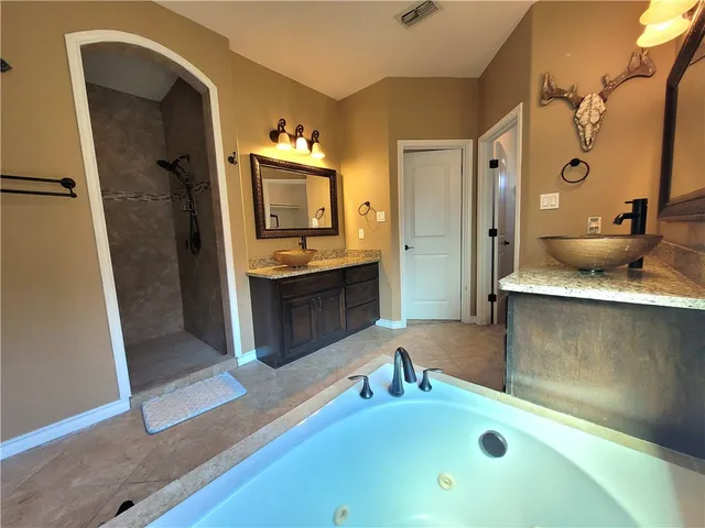 a bathroom with a tub sink and mirror