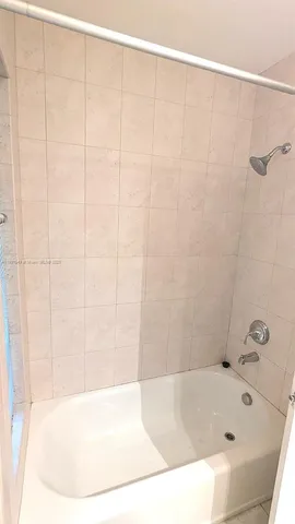 a bathroom with a white bath tub and a shower curtain