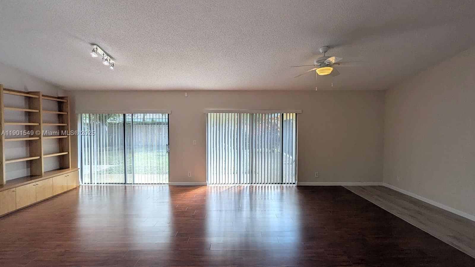 10140 Torchwood Avenue Plantation, FL 33324 - Photo 3 of 18 an empty room with wooden floor and windows