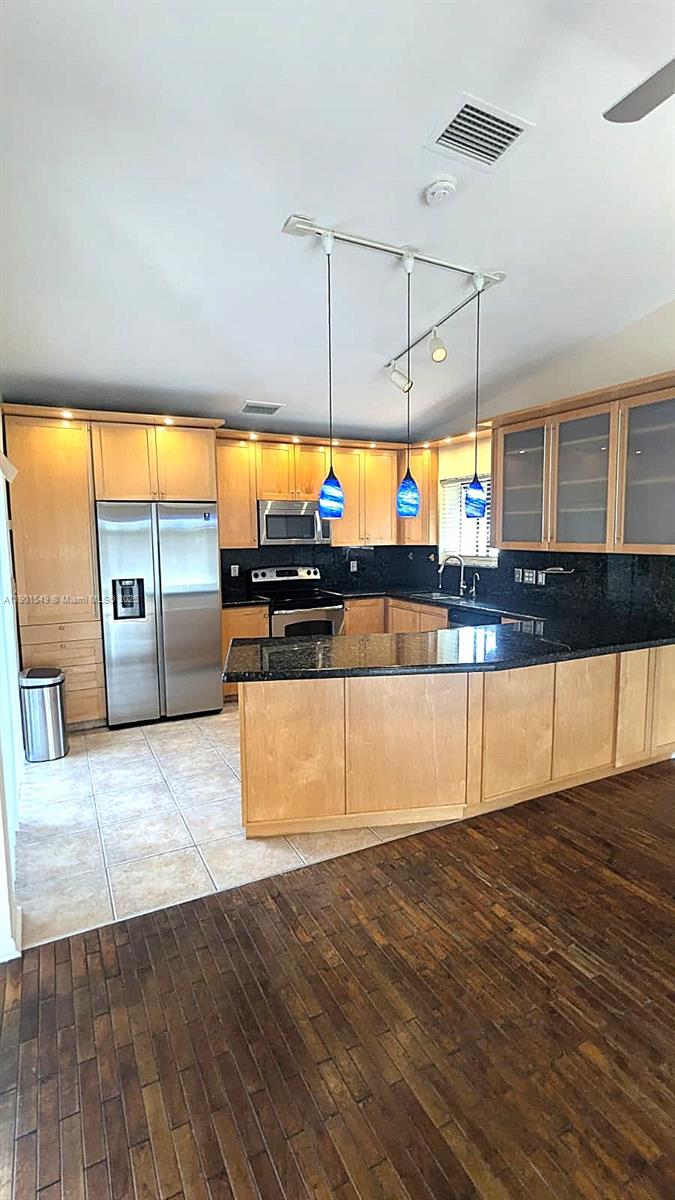 10140 Torchwood Avenue Plantation, FL 33324 - Photo 6 of 18 a kitchen with stainless steel appliances granite countertop a stove a sink and a wooden floors