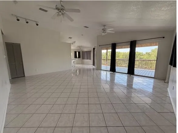 an empty room with floor to ceiling windows and chandelier