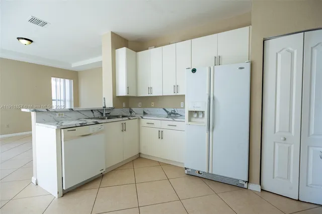 a kitchen with granite countertop white cabinets and white appliances