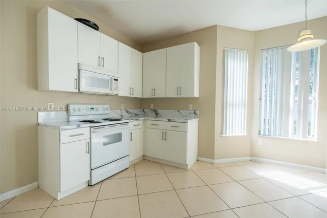 a kitchen with white cabinets appliances and a sink