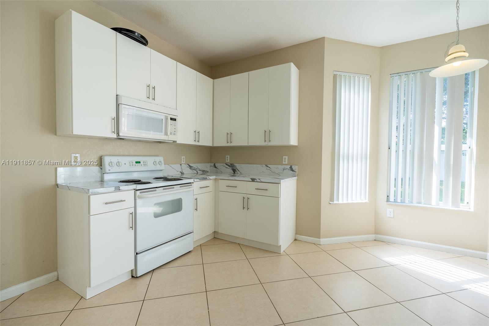 1770 Northeast 37th Place Homestead, FL 33033 - Photo 13 of 39 a kitchen with white cabinets appliances and a sink
