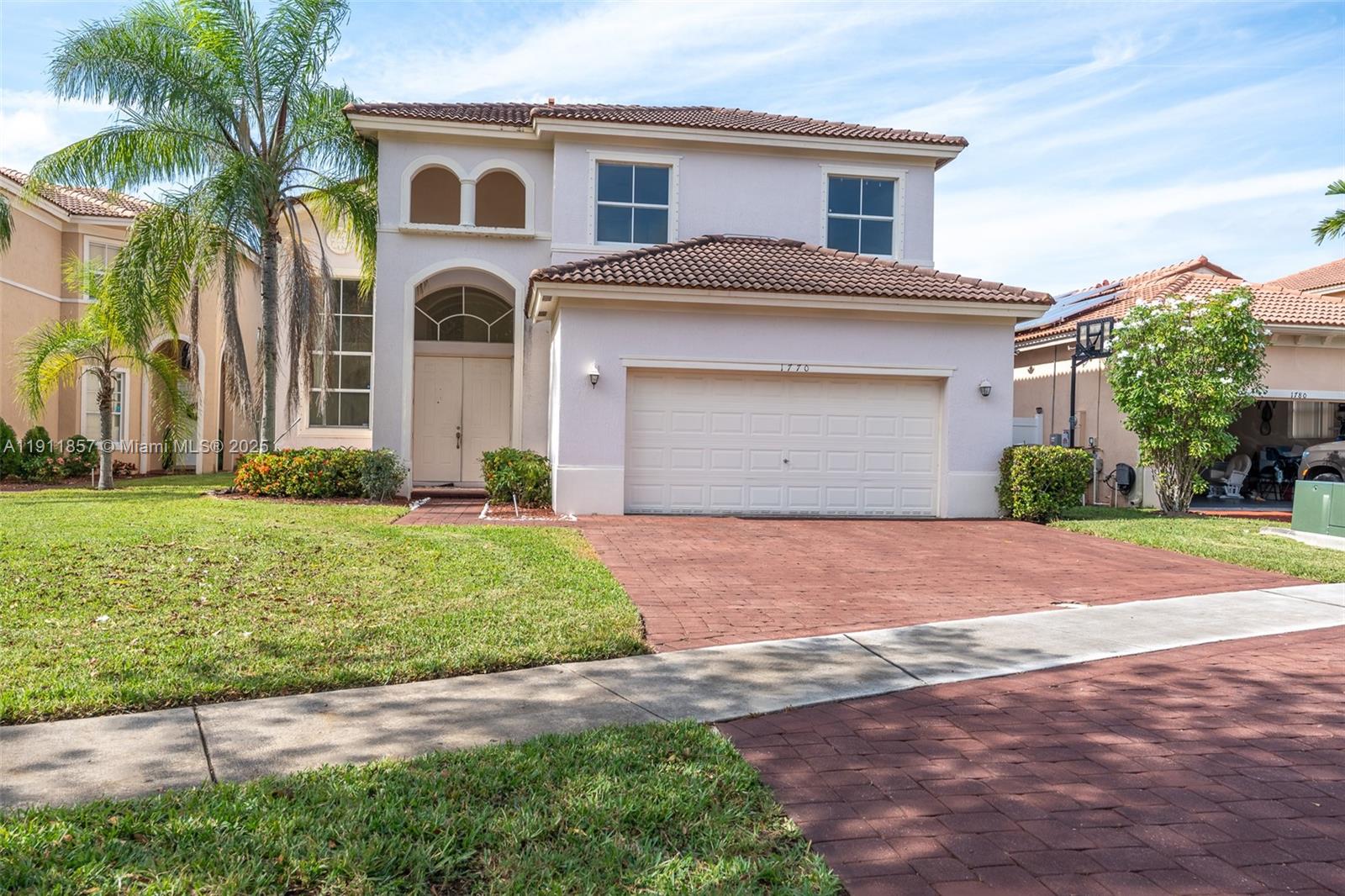 1770 Northeast 37th Place Homestead, FL 33033 - Photo 2 of 39 a front view of a house with a yard and garage