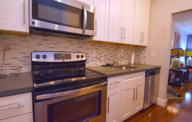 a kitchen with stainless steel appliances granite countertop a stove and a microwave