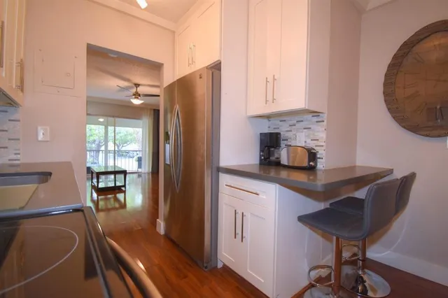a kitchen with stainless steel appliances granite countertop a sink refrigerator and cabinets