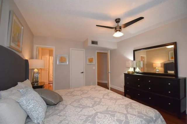 a bedroom with a bed and a mirror on dresser