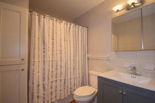 a bathroom with a toilet a sink and a mirror