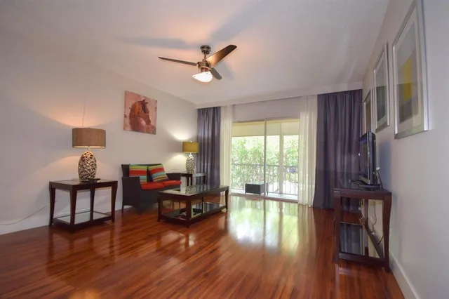 a living room with furniture and a wooden floor