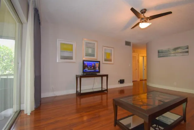 a living room with furniture and a wooden floor