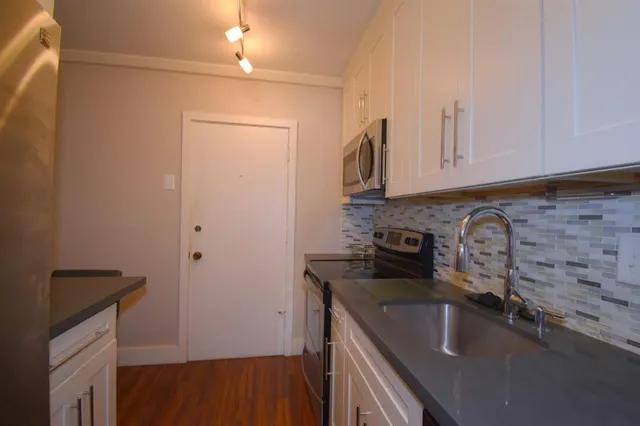 a kitchen with a sink cabinets and appliances
