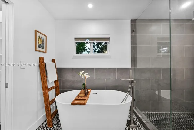 a bathroom with a tub sink and mirror