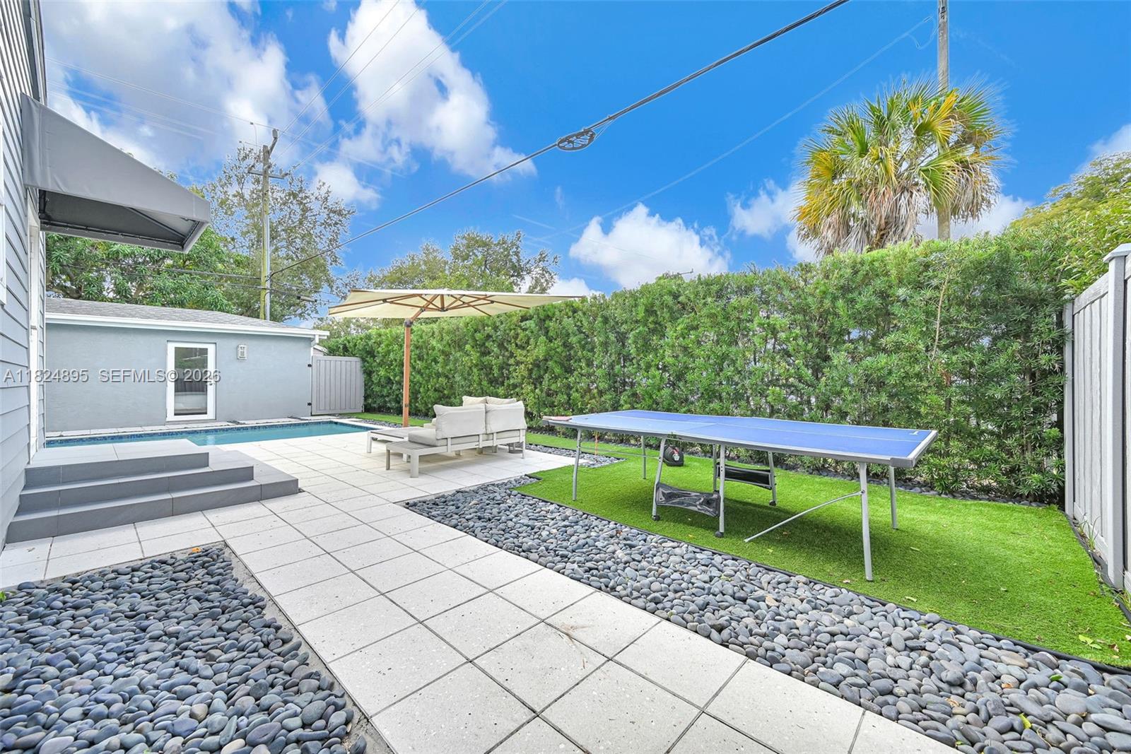 150 Northeast 50th Street, Unit A Miami, FL 33137 - Photo 81 of 100 a view of a chair and table in the backyard with a barbeque