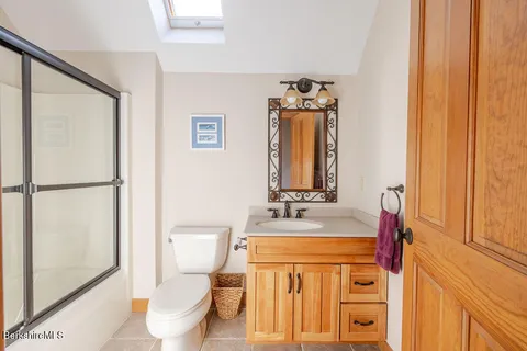 a bathroom with a sink vanity mirror and toilet