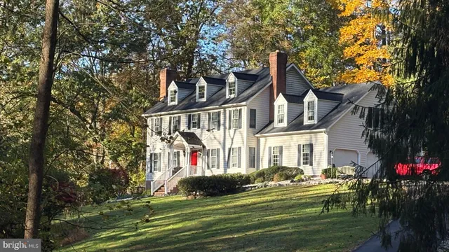 a front view of a house with a garden and trees