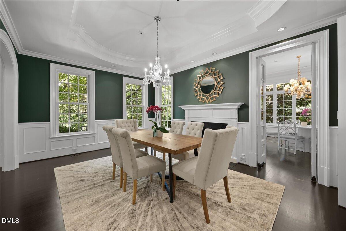 2525 Glenwood Avenue Raleigh, NC 27608 - Photo 4 of 39 a dining room with furniture a chandelier and wooden floor