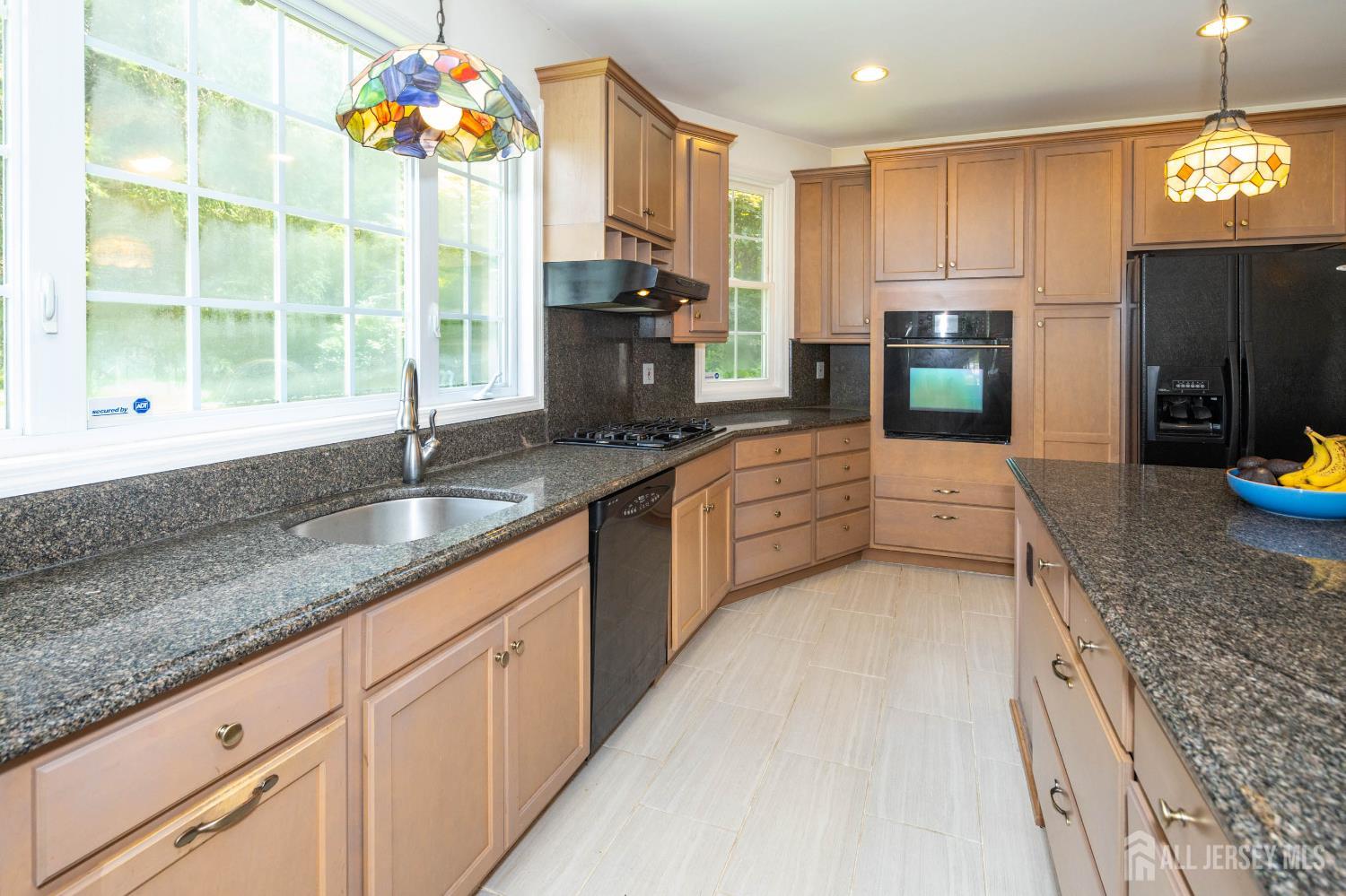 294 Fresh Ponds Road North Brunswick, NJ 08902 - Photo 15 of 53 a kitchen with kitchen island granite countertop a sink a counter top space appliances and cabinets