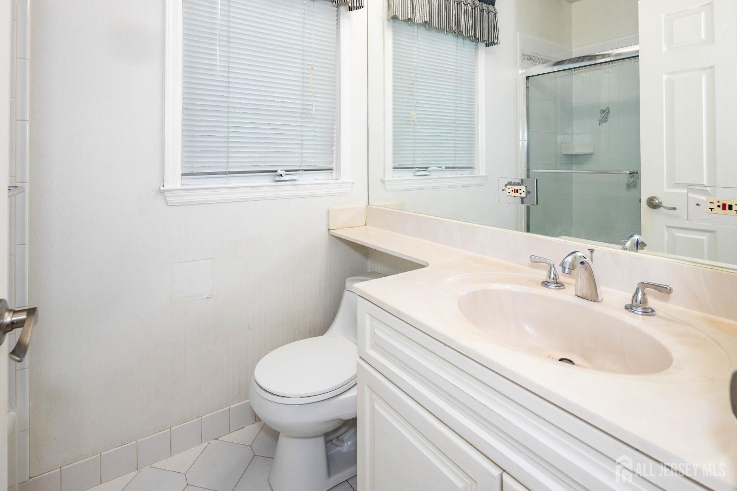 294 Fresh Ponds Road North Brunswick, NJ 08902 - Photo 19 of 53 a bathroom with a sink a toilet and a mirror