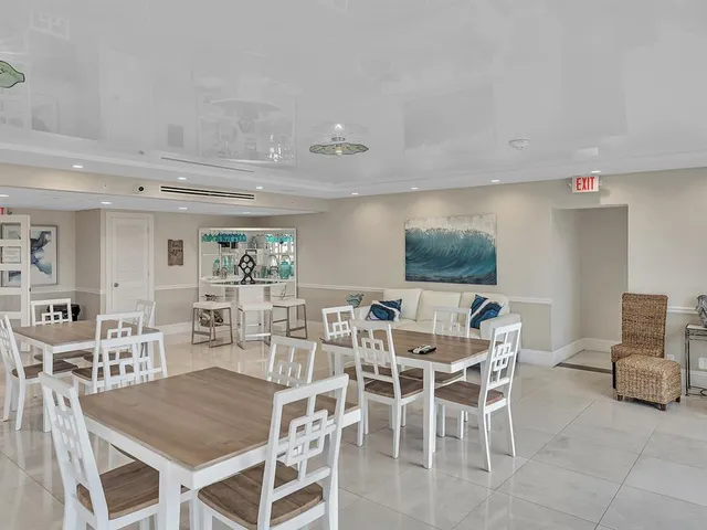 a dining room with stainless steel appliances granite countertop a table and chairs