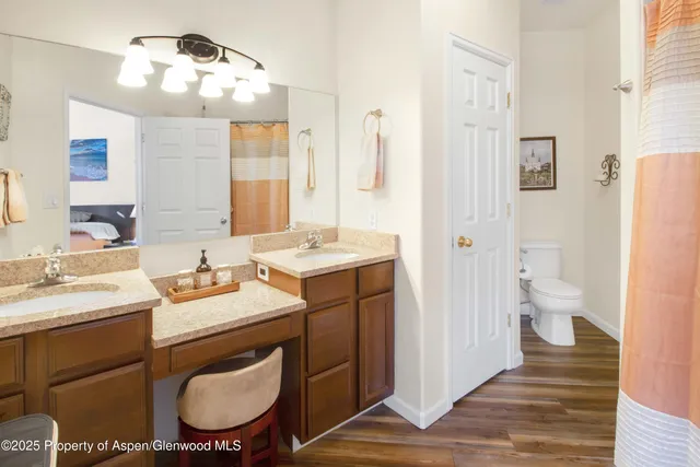 a spacious bathroom with a toilet a sink and a mirror