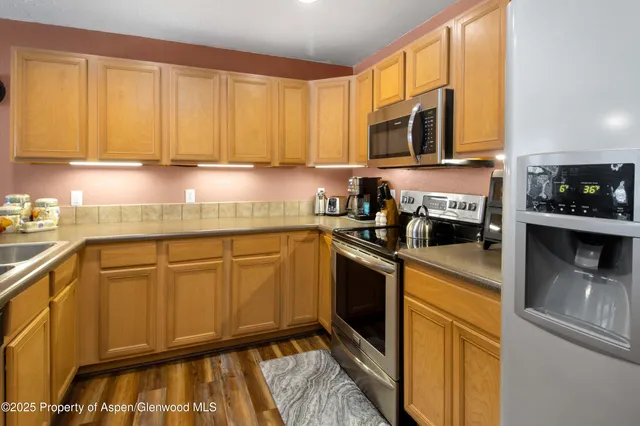 a kitchen with stainless steel appliances granite countertop white cabinets granite counter tops and a window