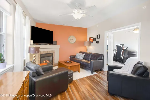 a living room with furniture a flat screen tv and a fireplace