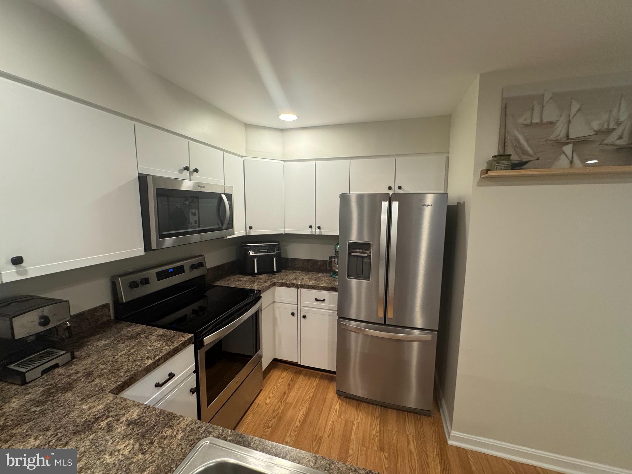 34 Queen Anne Way, Unit F Chester, MD 21619 - Photo 5 of 21 a kitchen with a refrigerator stove and microwave