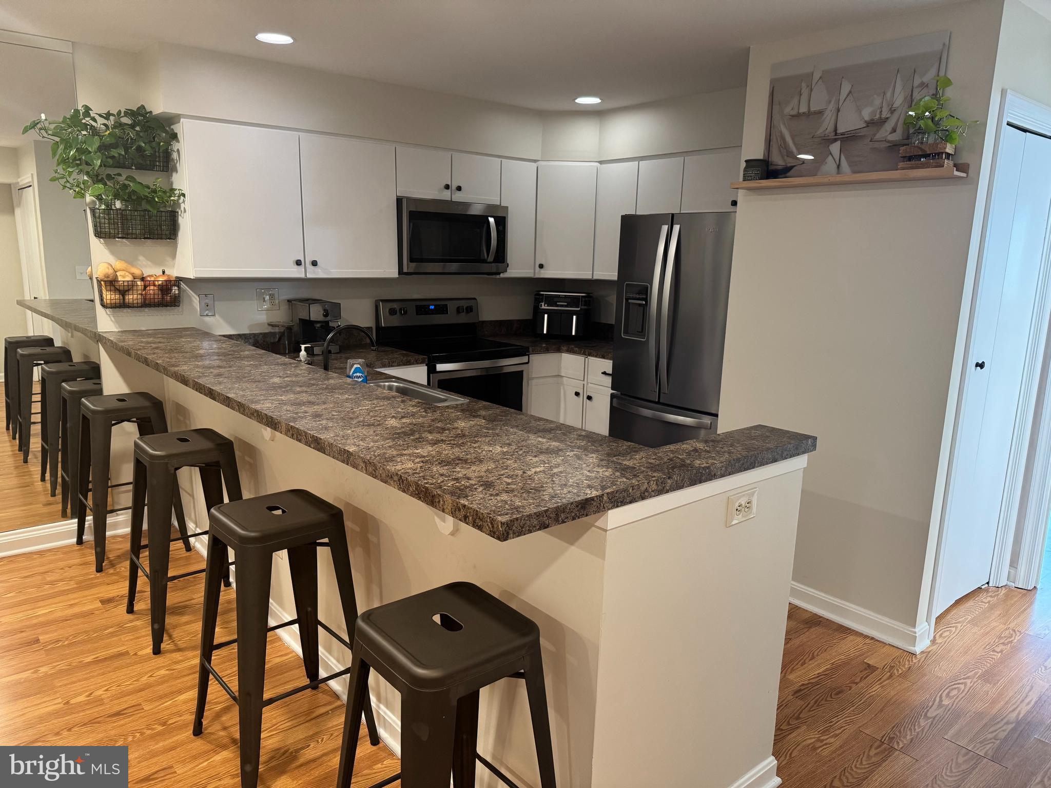 34 Queen Anne Way, Unit F Chester, MD 21619 - Photo 6 of 21 a kitchen with granite countertop a table chairs microwave and refrigerator