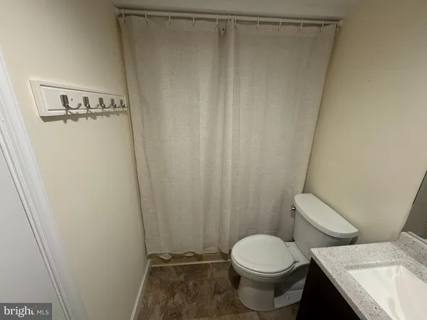 a white toilet sitting next to a shower