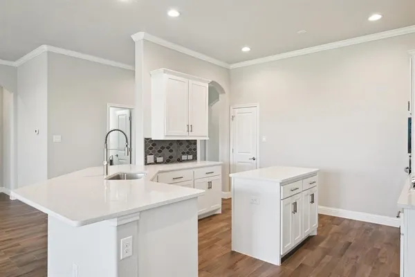 a kitchen with a sink a stove a refrigerator and white cabinets