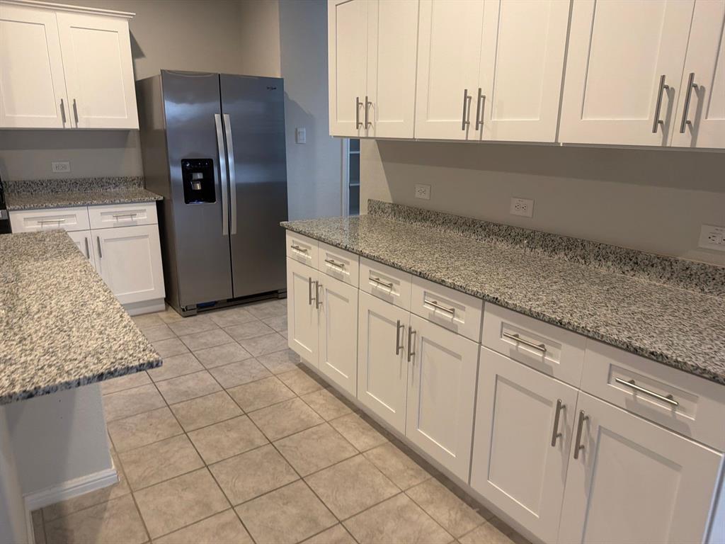 721 Durango Lane Cleburne, TX 76033 - Photo 5 of 25 a kitchen with stainless steel appliances granite countertop a sink and a refrigerator